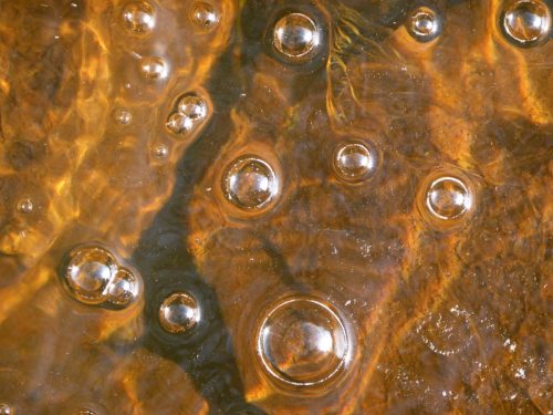 white bubbles orange ripples in stream