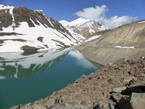 deep blue lake, snow and rocky roadside