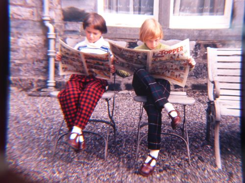 girls in check trousers reading comics
