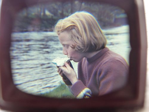 girl eating snack by stream