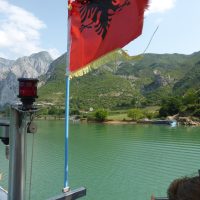 red flag against deep green lake