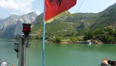 red flag against deep green lake