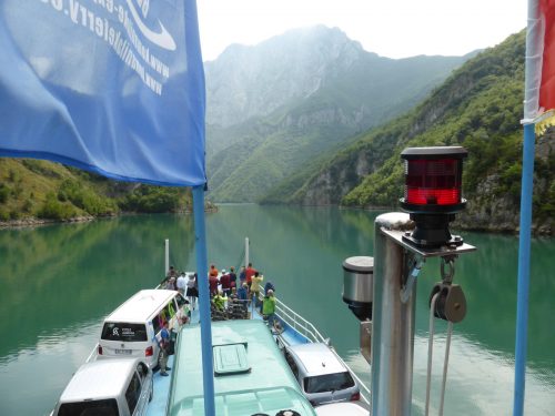 ferry travelling up lake with blue flag