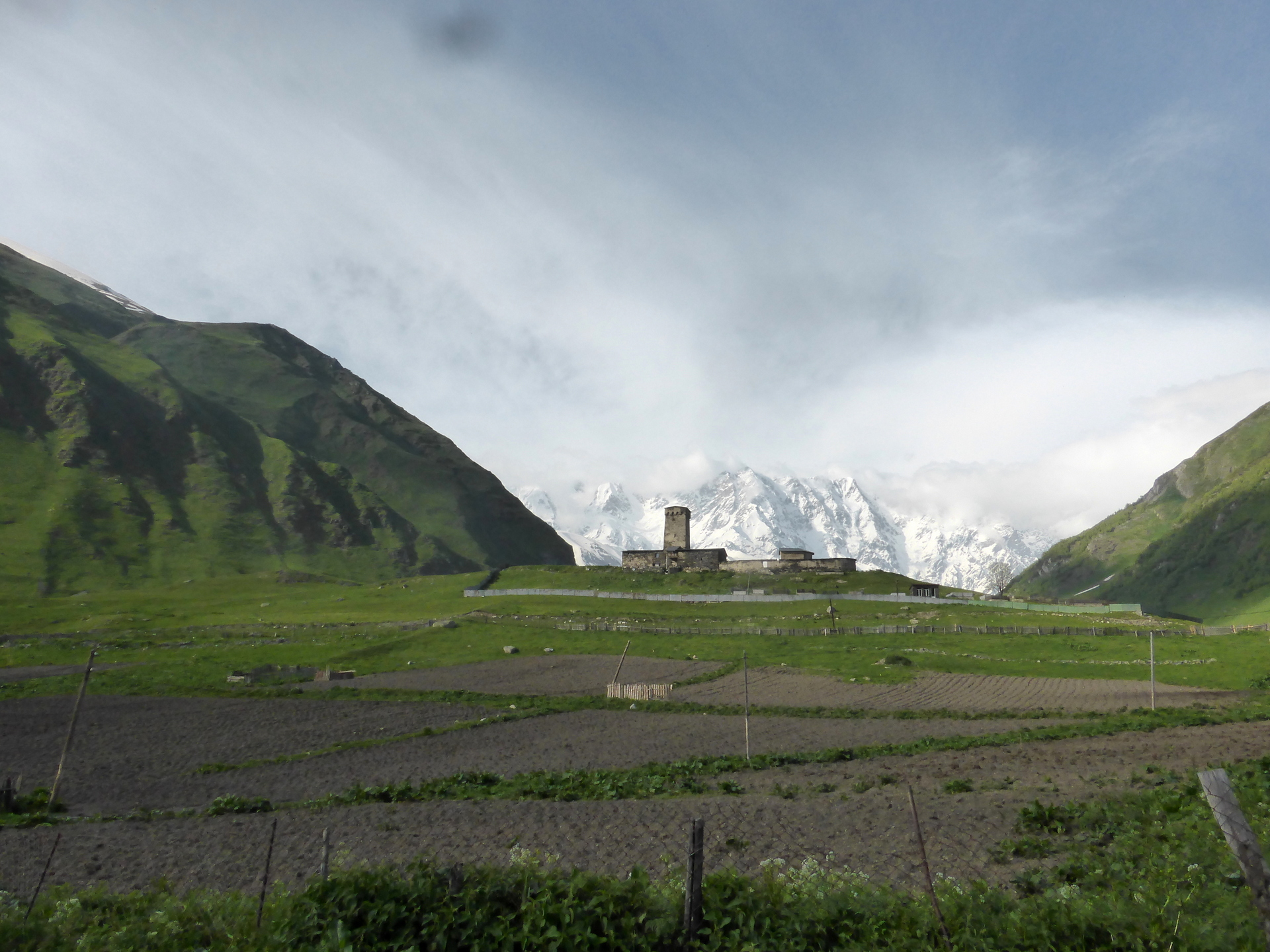 prepared fields, church and mountains