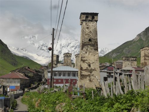 snowy mountains behind village towers