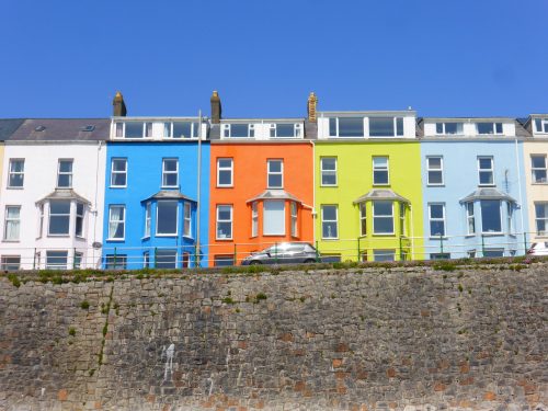 brightly coloured houses above beach