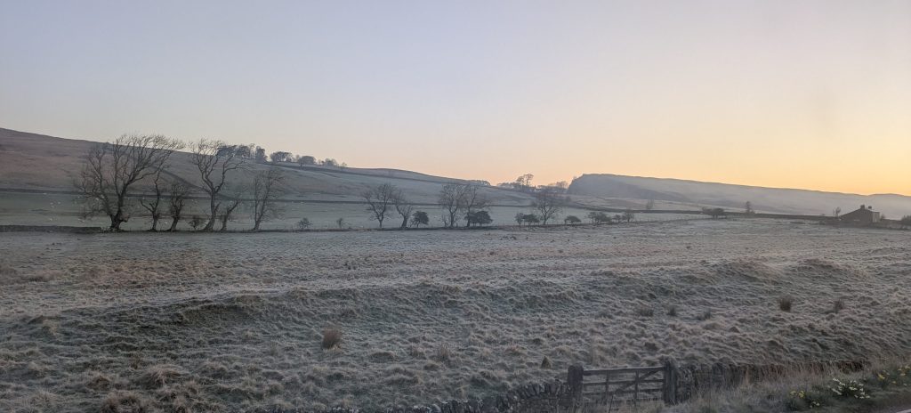 sunrise behind frosty fields